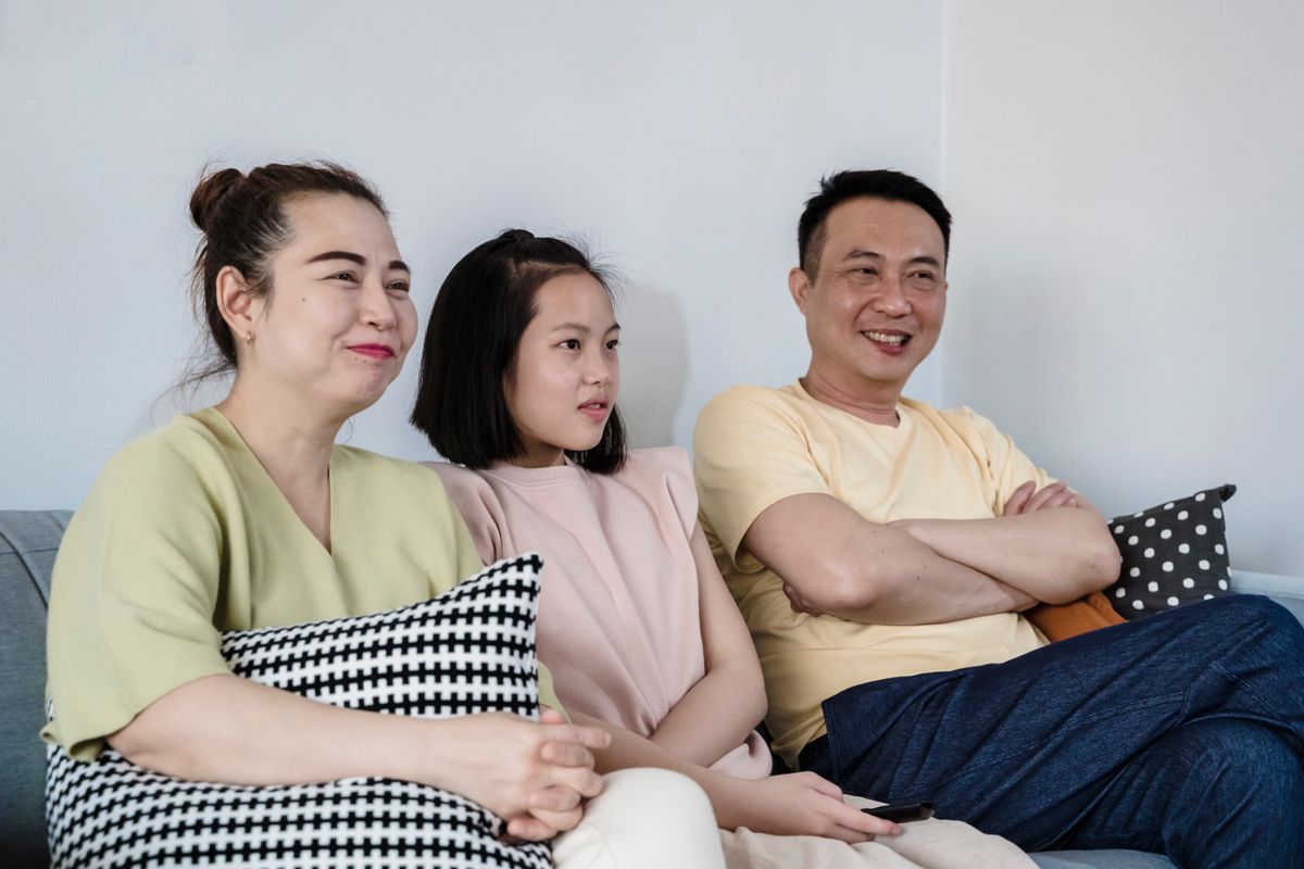 Parents and their daughter relaxing on the sofa at home