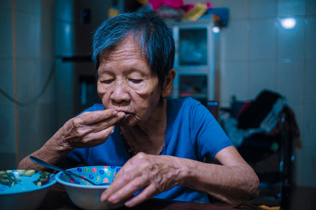 Elderly man having his evening meal at the kitchen table